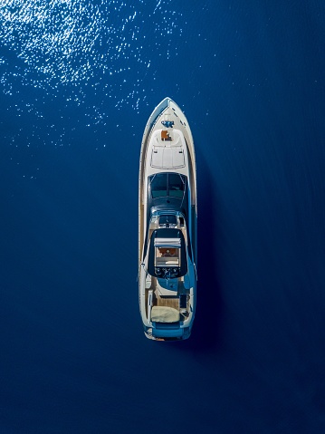 An aerial shot of a yacht sailing on the sea - great for background or a blog
