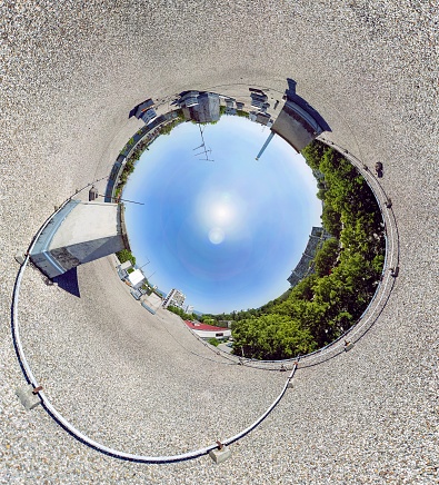 A 360-degree panoramic view of a building surrounded by greenery under sunlight in Zagreb in Croatia