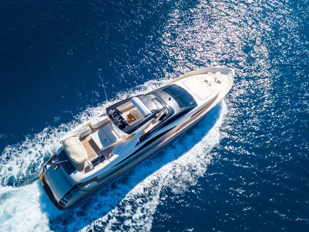 Aerial shot of a yacht sailing on the sea at daytime An aerial shot of a yacht sailing on the sea at daytime yachting stock pictures, royalty-free photos & images