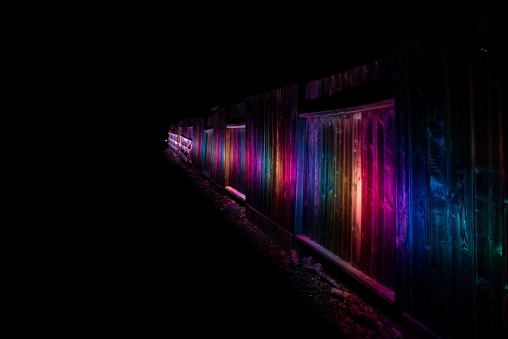 A beautiful RGB light painting along a fence at night time