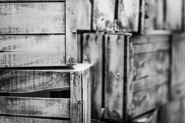 A large outdoor storage area displays numerous stacks of wooden pallet containers under a clear blue sky.