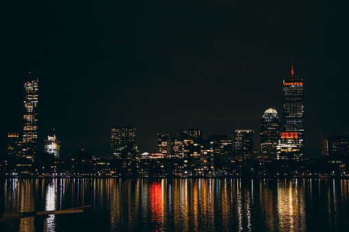 Boston, United States – December 28, 2021: The cityscape of Boston with the Charles river reflecting the city lights at night. United States.