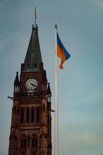 Peace tower at parliament hill in Ottawa Canada. Featuring a Ukrainian flag in support of their needless suffering.