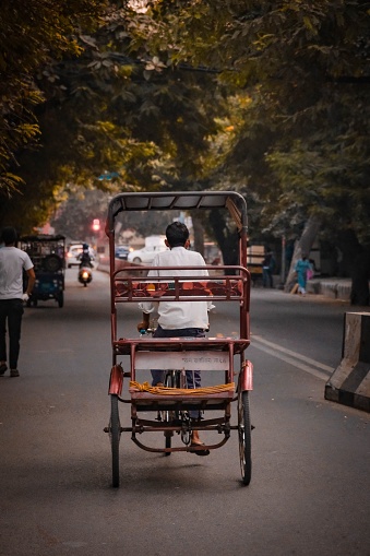 Delhi, India – October 25, 2022: A boy on a rickshaw in the streets of Dehli, India