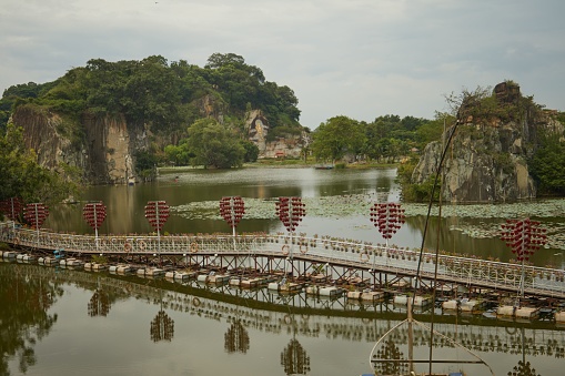 Nong Thale, a freshwater lake in Krabi Province, Thailand. The lake is surrounded by limestone mountains and lush vegetation, and there is a small island in the middle of the lake.