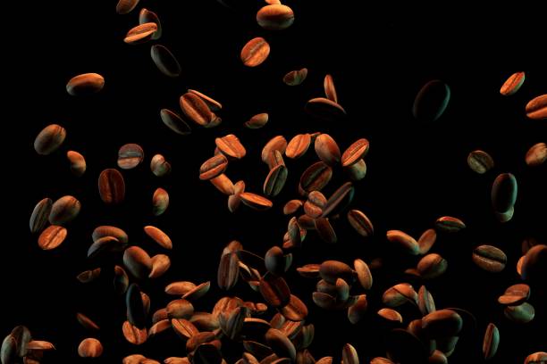 Closeup of brown coffee beans falling down isolated on a black background