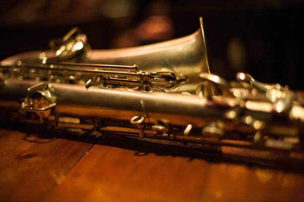 close-up tiro de um saxofone barítono em uma mesa de madeira - close up musical instrument saxophone jazz - fotografias e filmes do acervo