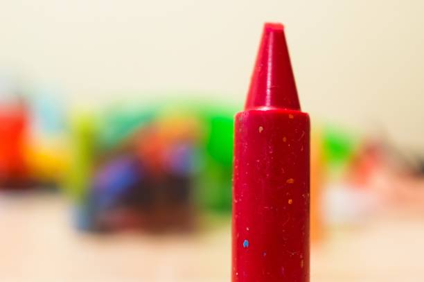 A closeup shot of a red crayon with a blurred background