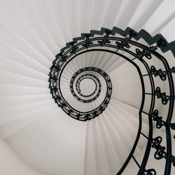 istock High angle view of a modern spiral staircase under the lights 1438616978