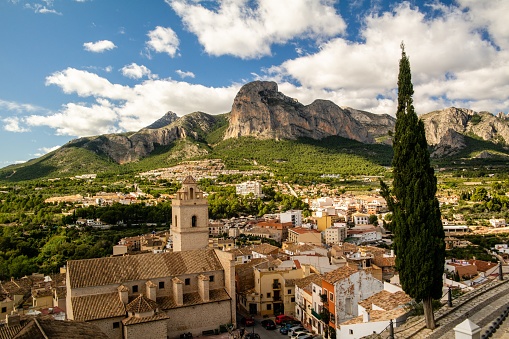 A bird's eye view of old buildings and beautiful nature of Polop, Spain with rocky mountains in the background
