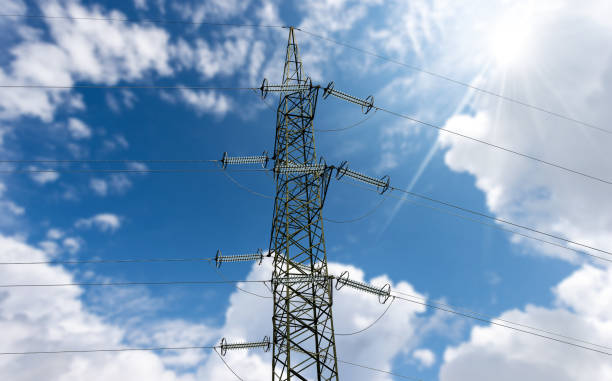 istock High voltage tower - Power Line Against a Blue Sky with Clouds and Sunbeams 1438618151