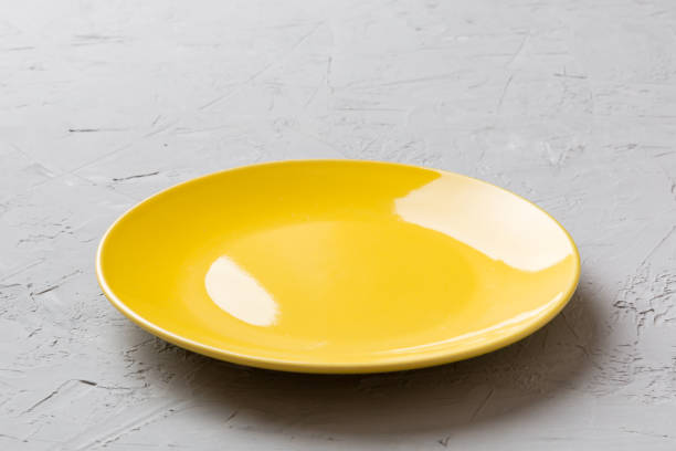 Perspective view of empty blue plate on cement background. Empty space for your design.