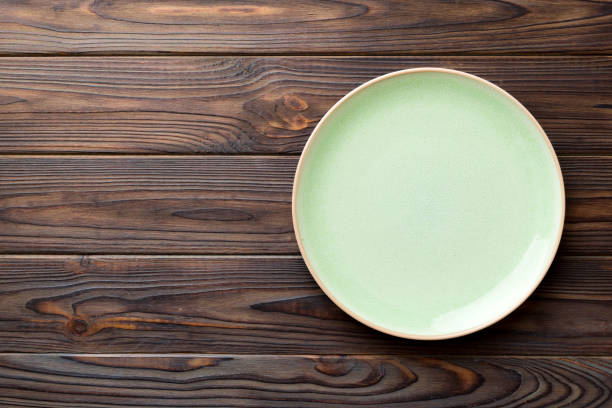 istock Top view of empty blue plate on wooden background. Empty space for your design 1438622472