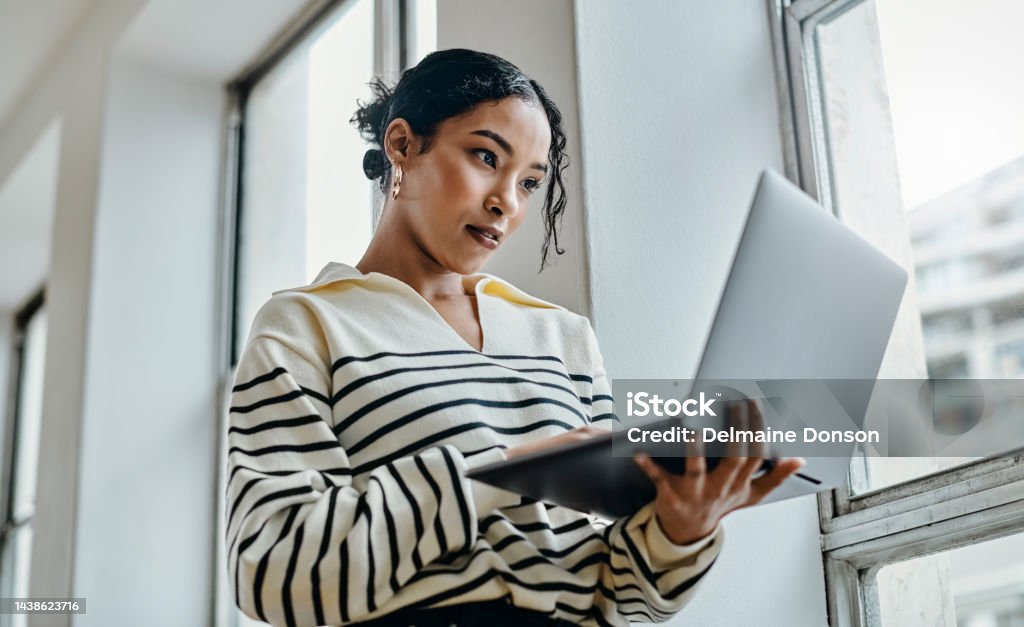 Black woman with laptop reading, typing and working for online digital newspaper, marketing or advertising company. Girl check email, post blog feedback or review social media content writing article Marketing Stock Photo