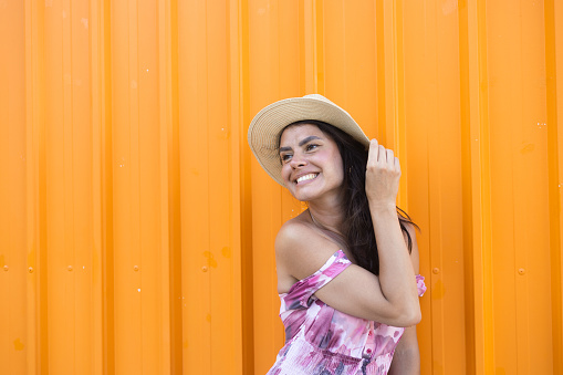 Portrait of a beautiful young woman in front of the orange background