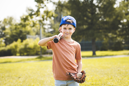 A Young boy with blue baseball cap on a field