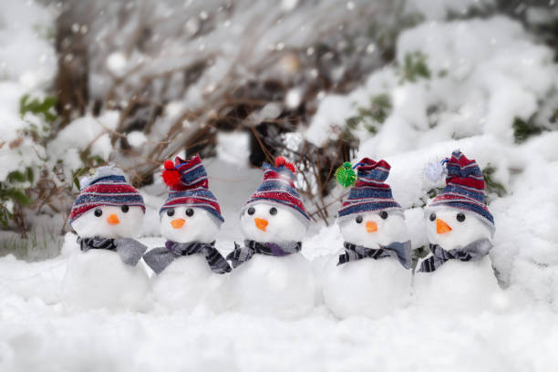 Five cute mini snowmen dressed for winter stock photo