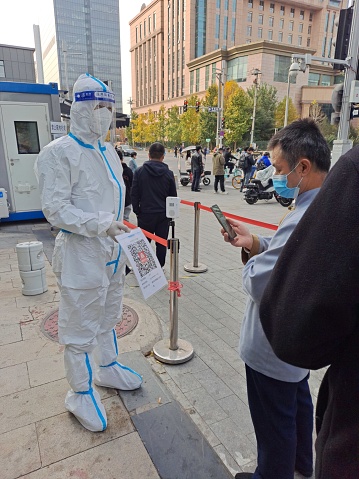 Beijing, China - November 2, 2022:   People scanning health code for covid test on street under China's zero covid policy.