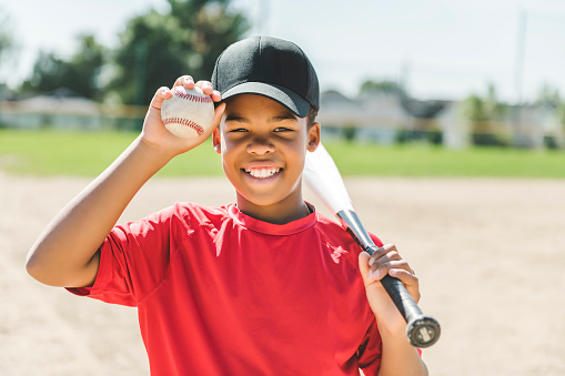 A portrait of child with glove and looking at camera playing baseball