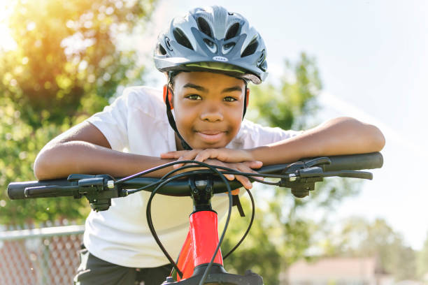 istock boy riding bike wearing a helmet outside 1438631401