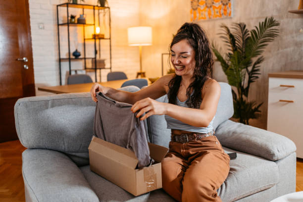 istock Young Woman Unboxing A Package With A New Shirt 1438631471