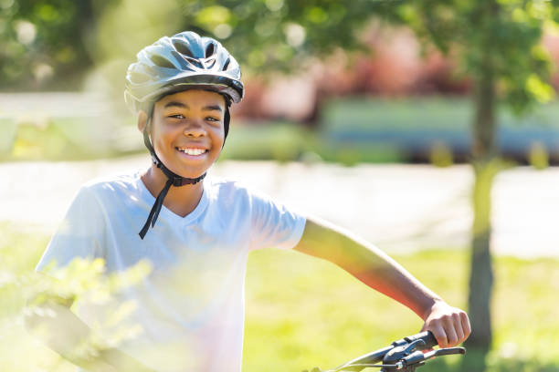 istock boy riding bike wearing a helmet outside 1438632097
