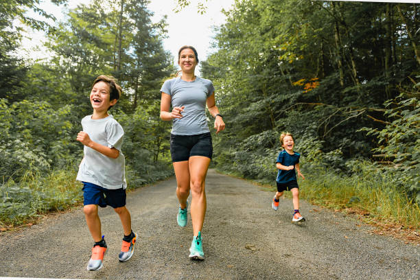 istock mother and sons running outside in forest 1438635231