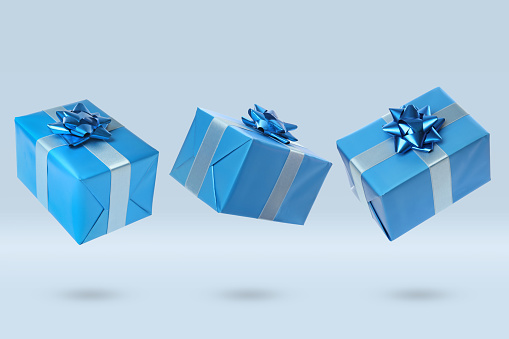Beautifully wrapped gift boxes flying on light background