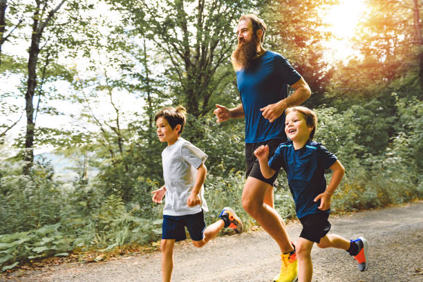 istock father and two sons running outside in forest 1438637266