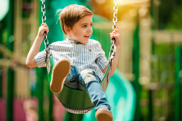 Baby boy having fun on a swing.