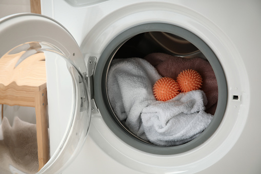 Dryer balls and towels in washing machine, closeup
