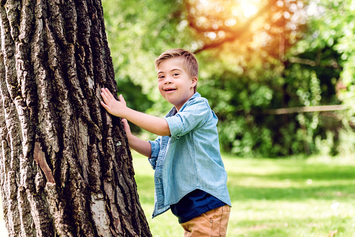 A Portrait of a little boy with down syndrome while playing in a park