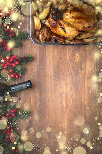 Christmas or Thanksgiving background with fir branches and grilled chicken With golden snowflakes with copy space for text