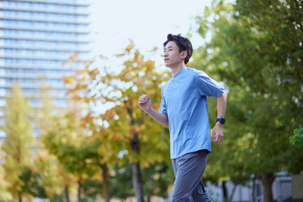 junger japaner in sportkleidung - men jogging running sports training stock-fotos und bilder