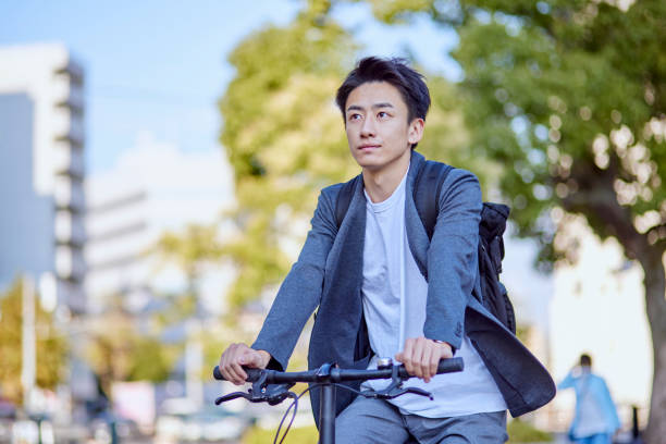 自転車に乗るジャケットを着た若い日本人男性 - 男性のみ ストックフォトと画像