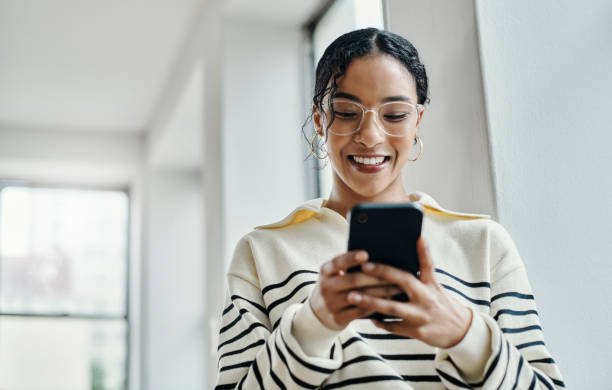istock Phone, communication and networking with a black woman in business typing a text message in her office. Contact us, social media and email with a female employee texting with mobile technology 1438644248