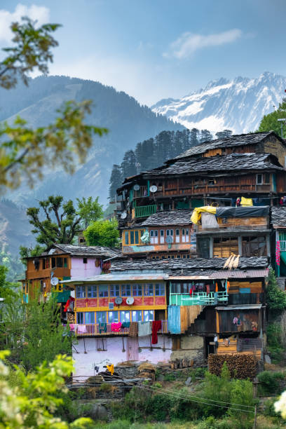 a colorful view of quaint dunkhari village in lug valley himachal with snow-laden sari ra jot adorning the background - uttarakhand bildbanksfoton och bilder