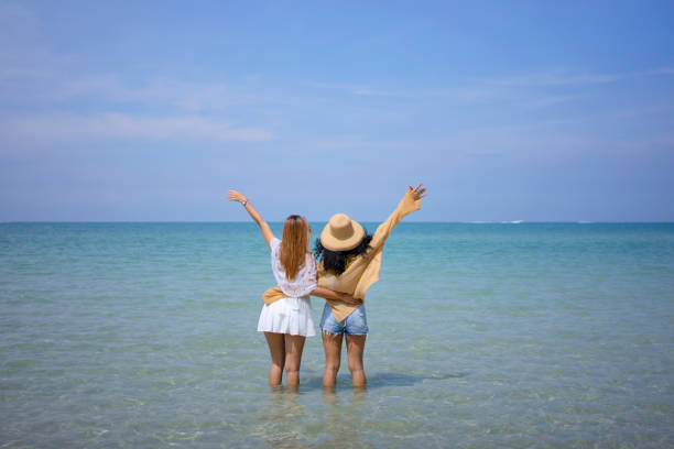 beautiful girl in thin white shirt splashes in water on the beach of adriatic sea
