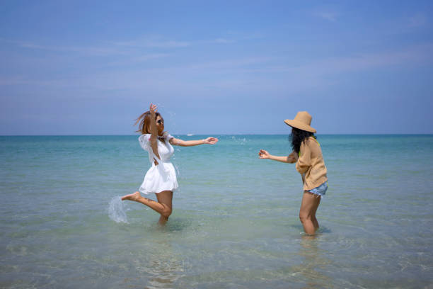 Female Friends Walking On Riverbank