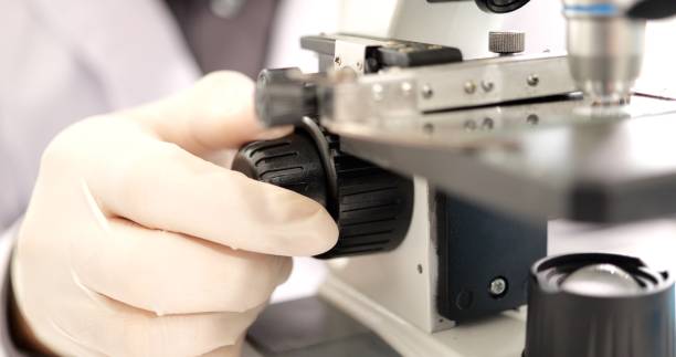 istock Close up view of scientists hand using microscope in medical science laboratory, Researcher analyzing of test sample, Professional biotechnology specialist working with advanced equipment 1438655186