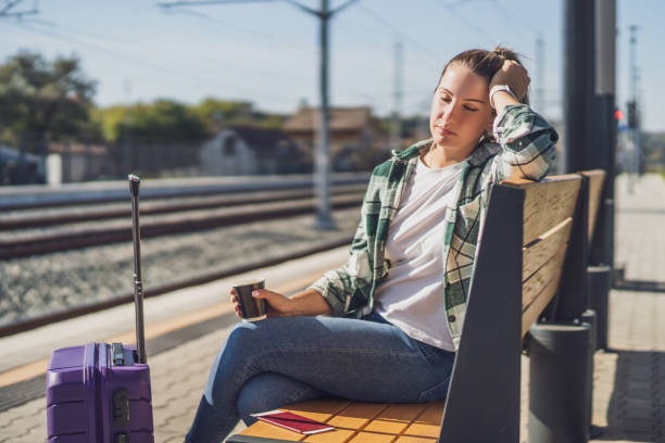 istock Tired  woman with coffee  sleeping on a  train station 1438660420
