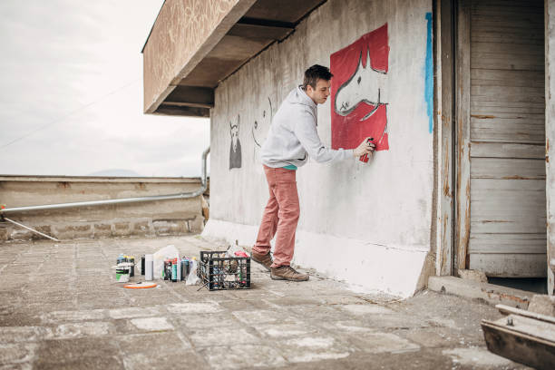 istock Artist painting graffiti on wall 1438661513