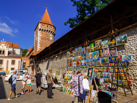 Krakow, Poland - August 12, 2022: Street artist selling her paintings in front of the Florian's Gate in the old town.