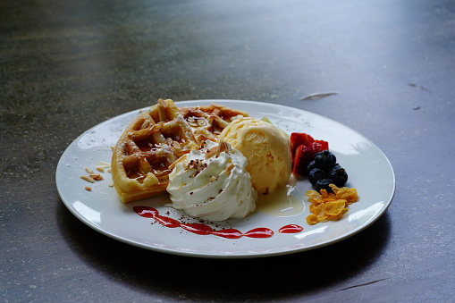 Homemade waffles with ice cream on white  plate