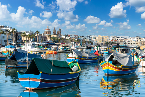 Landscape with traditional Luzzu boat in harbor of Marsaxlokk, Malta islands