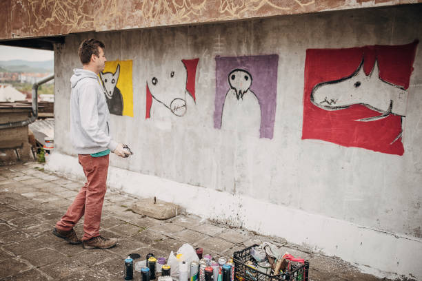 istock Man painting graffiti on wall 1438668025