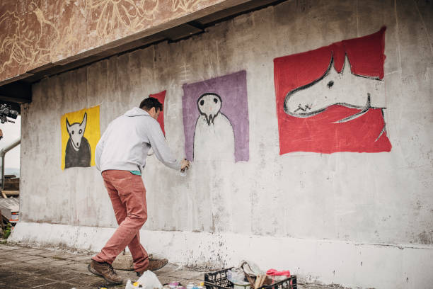 istock Man painting graffiti on wall 1438668618