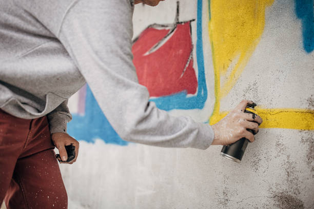 istock Man painting graffiti on wall 1438669104