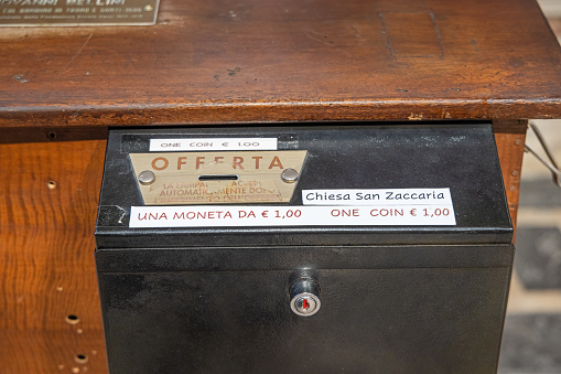 Venice, Italy - October 10th 2022: Collection box asking for donations in Euro in a old Italian church called Chiesa di San Zaccaria in the center of the old and famous old Italian city Venice