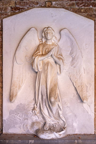 San Michele, Venice, Italy - October 8th 2022:  San Michele is a small island in the Venetian lagoon where the cemetery for the city is placed.  The picture shows a old relief of an angel made of marble